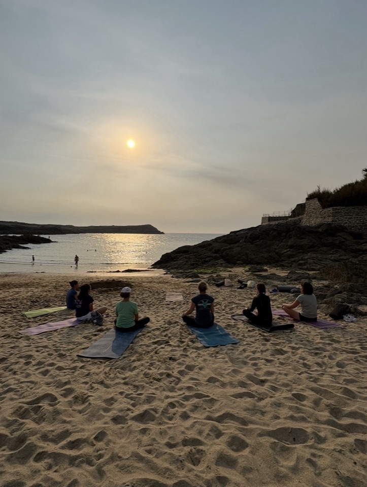Séance de Yoga en plein air sur une plage de Saint-Malo au coucher du soleil