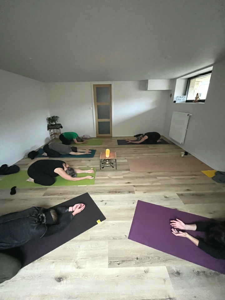Groupe en posture de l'enfant sur les tapis du studio, autour d'une bougie