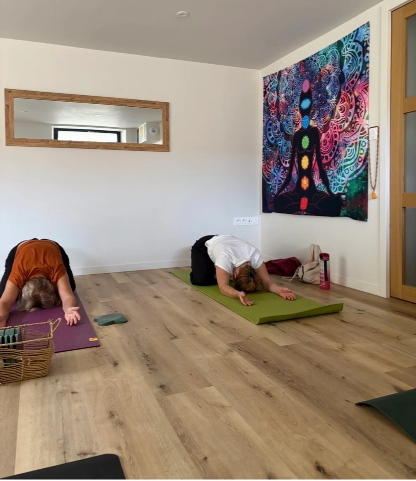 Deux élèves en posture de l'enfant sur leurs tapis, dans le studio de Paramé